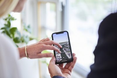 Handen gebruiken een smartphone met een kaartweergave op het scherm.